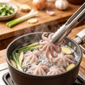Baby octopus blanching in a pot of simmering broth